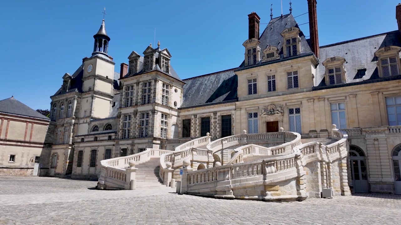 Slowmotion-optagelse af Hestesko-trappen og renæssancefacaden i hovedgårdspladsen på Château de Fontainebleau, filmet i Frankrig
