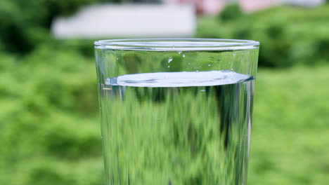 ripples and waves formed by droplets of liquid that fall into a glass filled with water