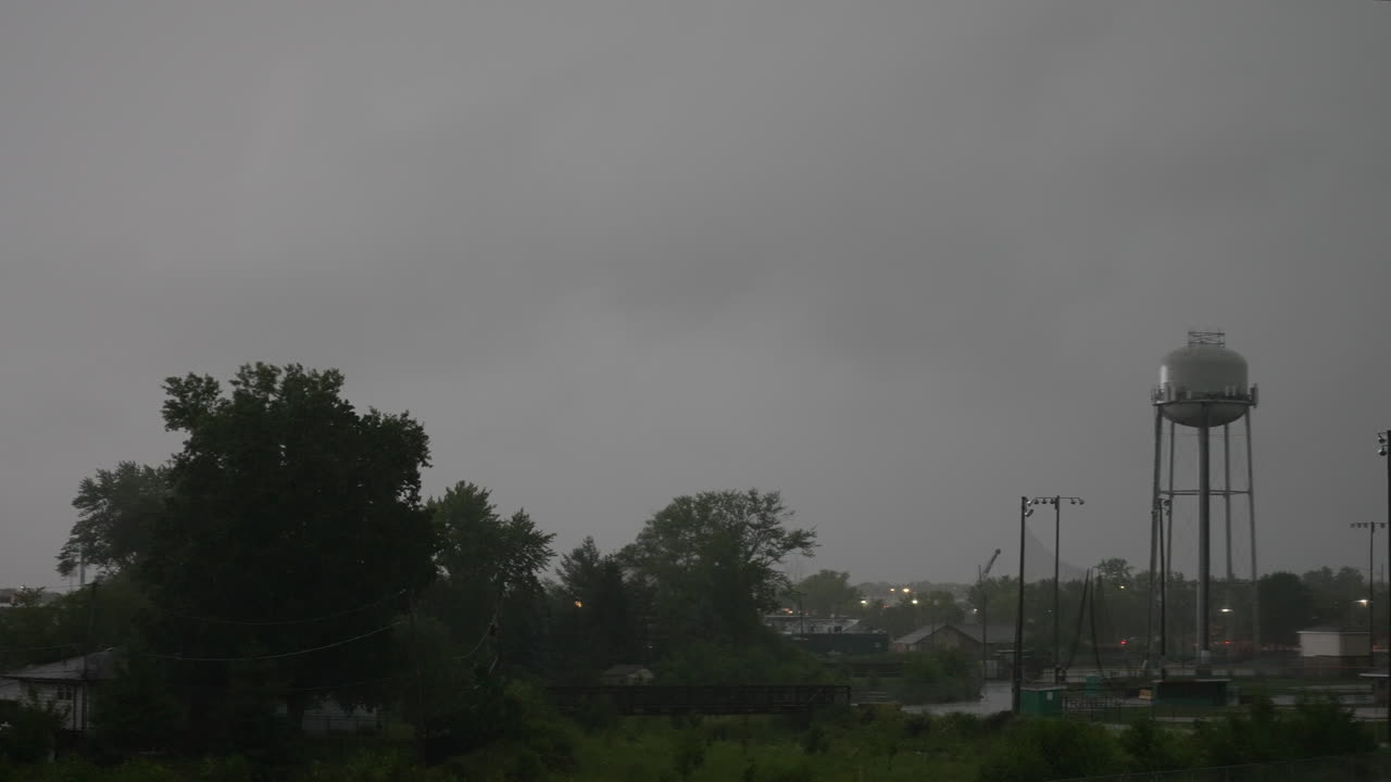 雷雨の中の給水塔と小川のタイムラプス