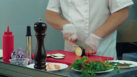 cook cuts eggplant for salad