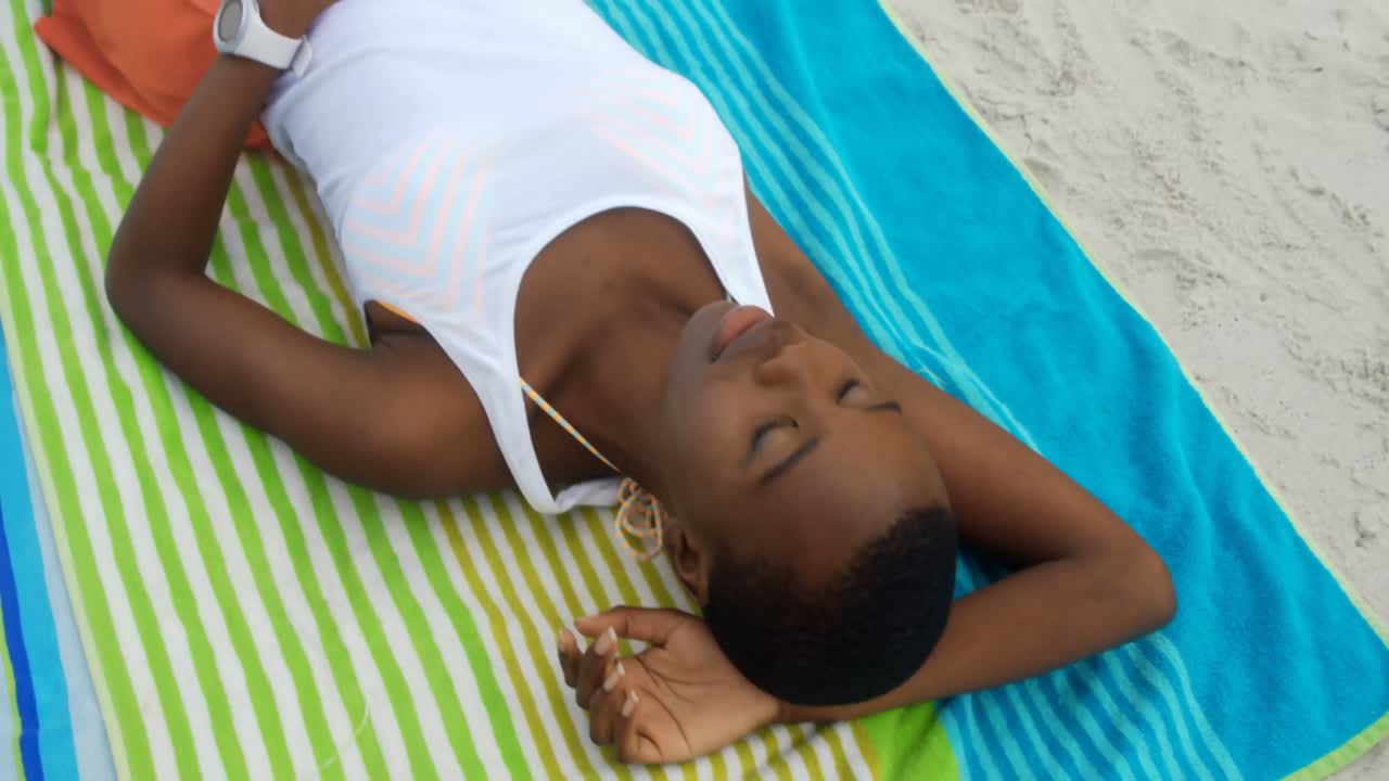 High angle view of African american woman sleeping on the beach 4k