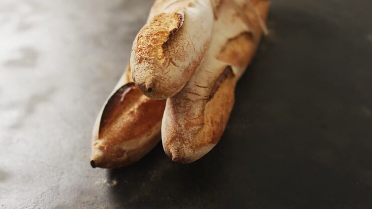 Video of baguettes tied with lace on a black surface