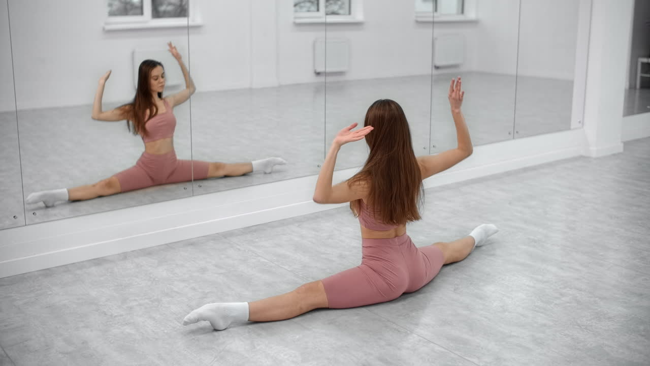 Woman practicing splits in a dance studio