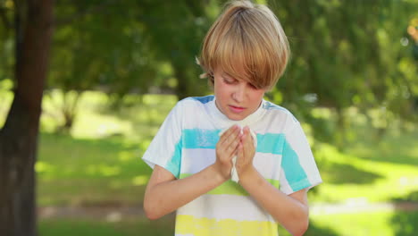 little boy blowing his nose