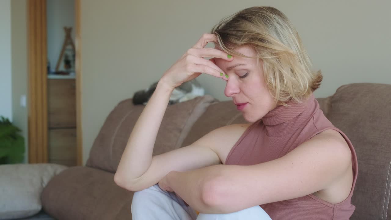 A woman experiencing sadness and anxiety at home