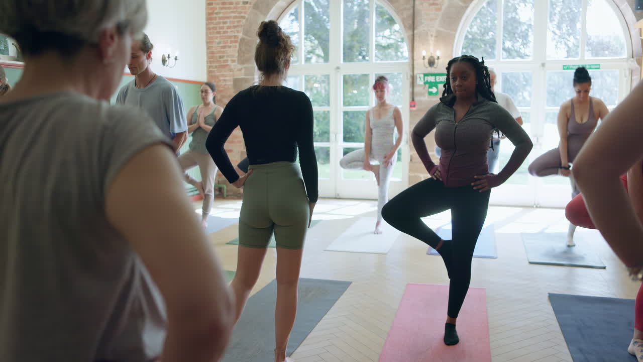Yoga class practicing tree pose