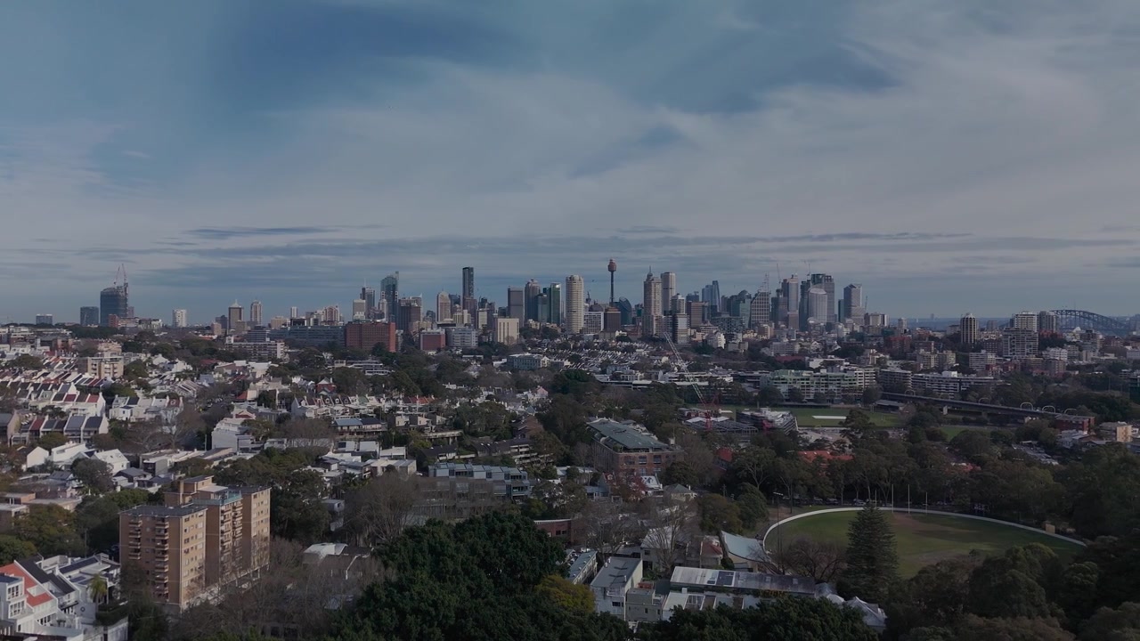 Paddington aerial view of Sydney CBD. Camera orbits above trees to reveal citty and harbor view.