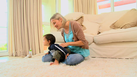 Young-mother-playing-with-her-baby-on-the-carpet-