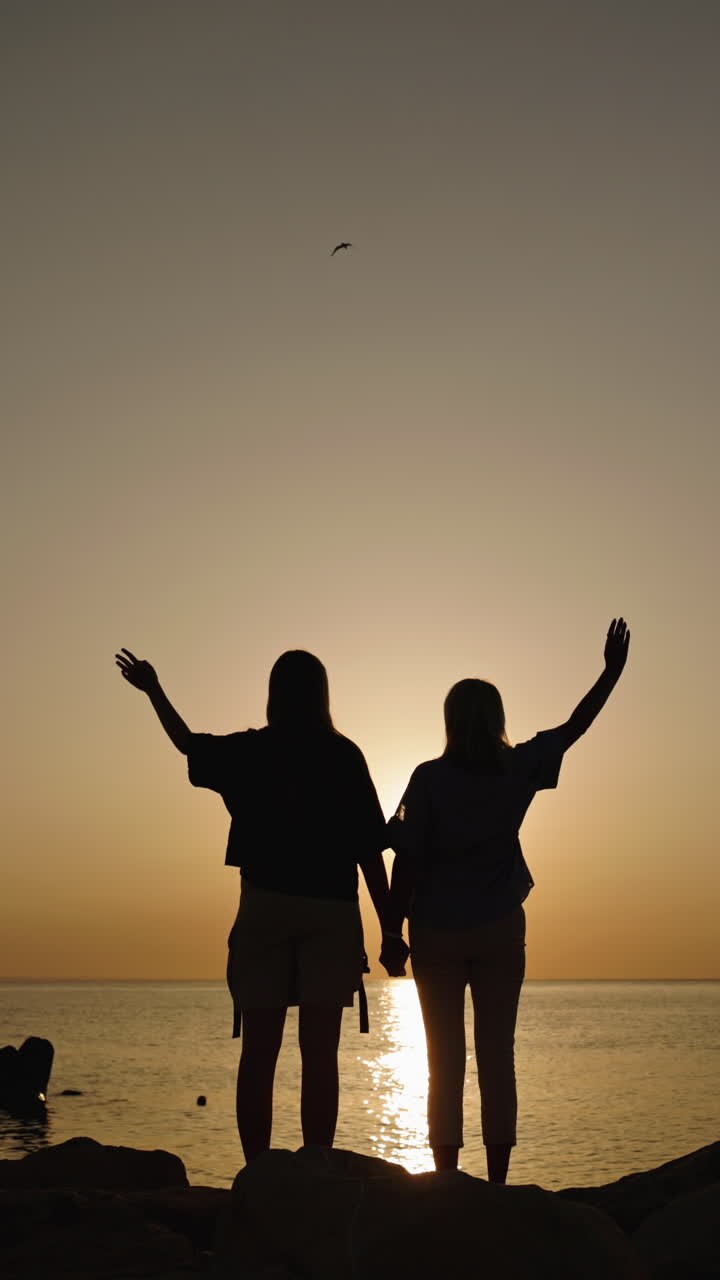 Dos amigos disfrutando de una preciosa puesta de sol en la playa