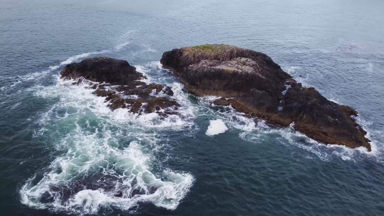 un video de dron giratorio que rodea algunas rocas grandes sobre el océano