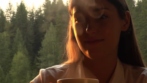 woman enjoying a hot drink in nature at golden hour