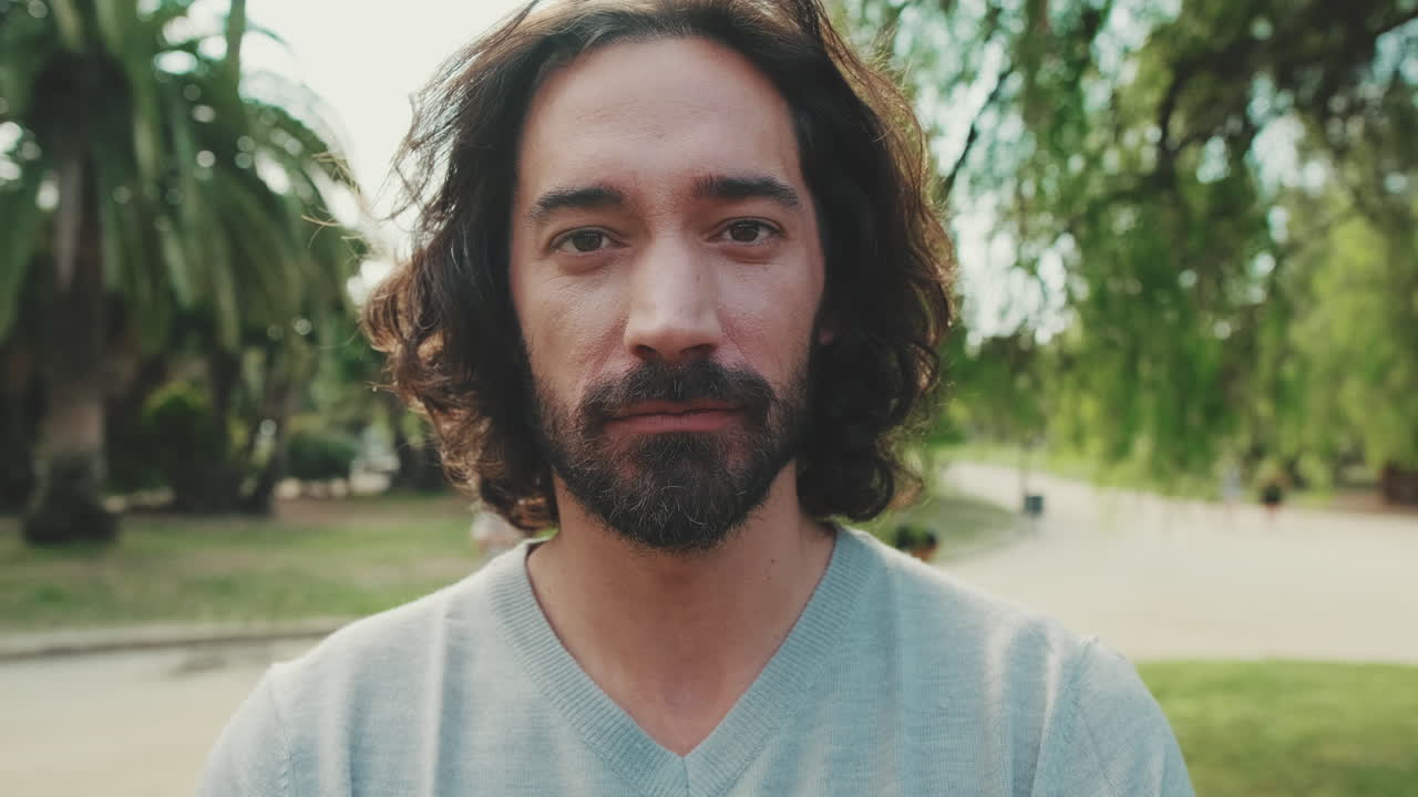 Uomo sorridente con la barba al parco