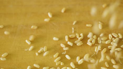 close-up of dried grains of wheat spilling onto a wooden table in slow motion