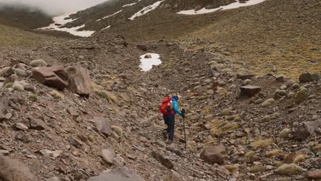 un turista recoge una botella de plástico de basura en el parque nacional de las montañas del alto atlas