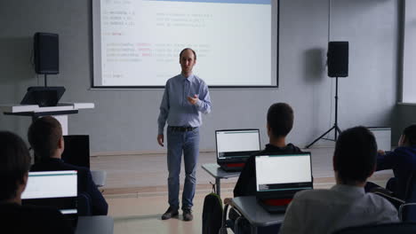 teacher lecturing students in a computer science class