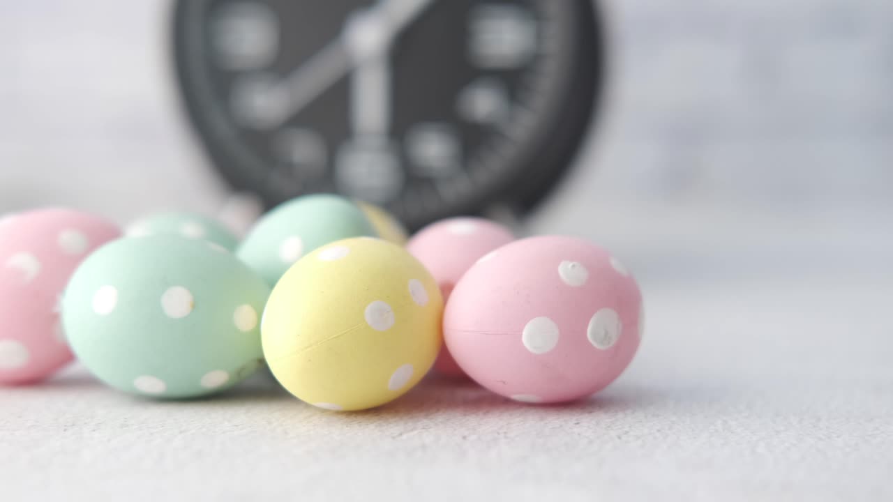 Uova di Pasqua puntinate color pastello con orologio