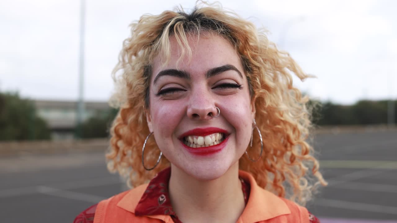 joven feliz sonriendo a la cámara al aire libre