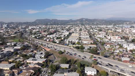 East-Hollywood,-California-and-US-Route-101---pullback-aerial-reveal-at-daytime