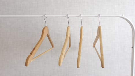 empty wooden hangers on a white rod