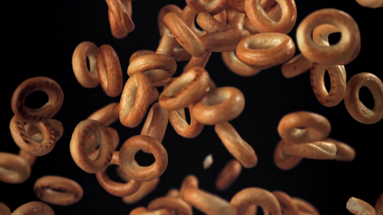 Golden Ring-Shaped Biscuits Falling in Slow Motion