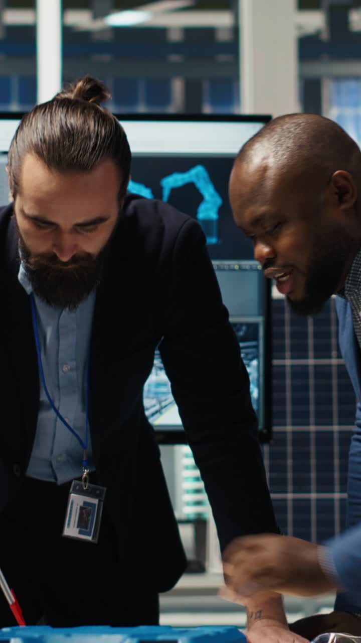 Vertical video Factory management looking over schematics to expand production