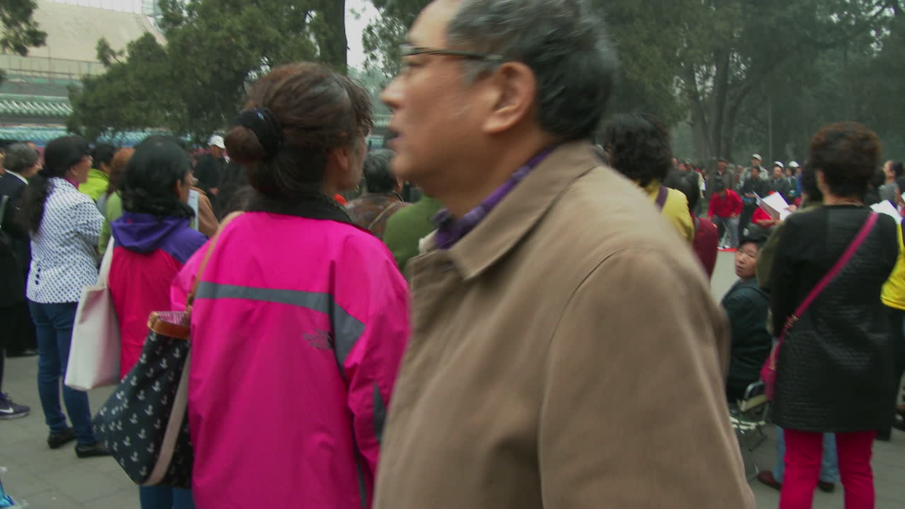 люди в китайском пекине поют патриотическую песню в парке