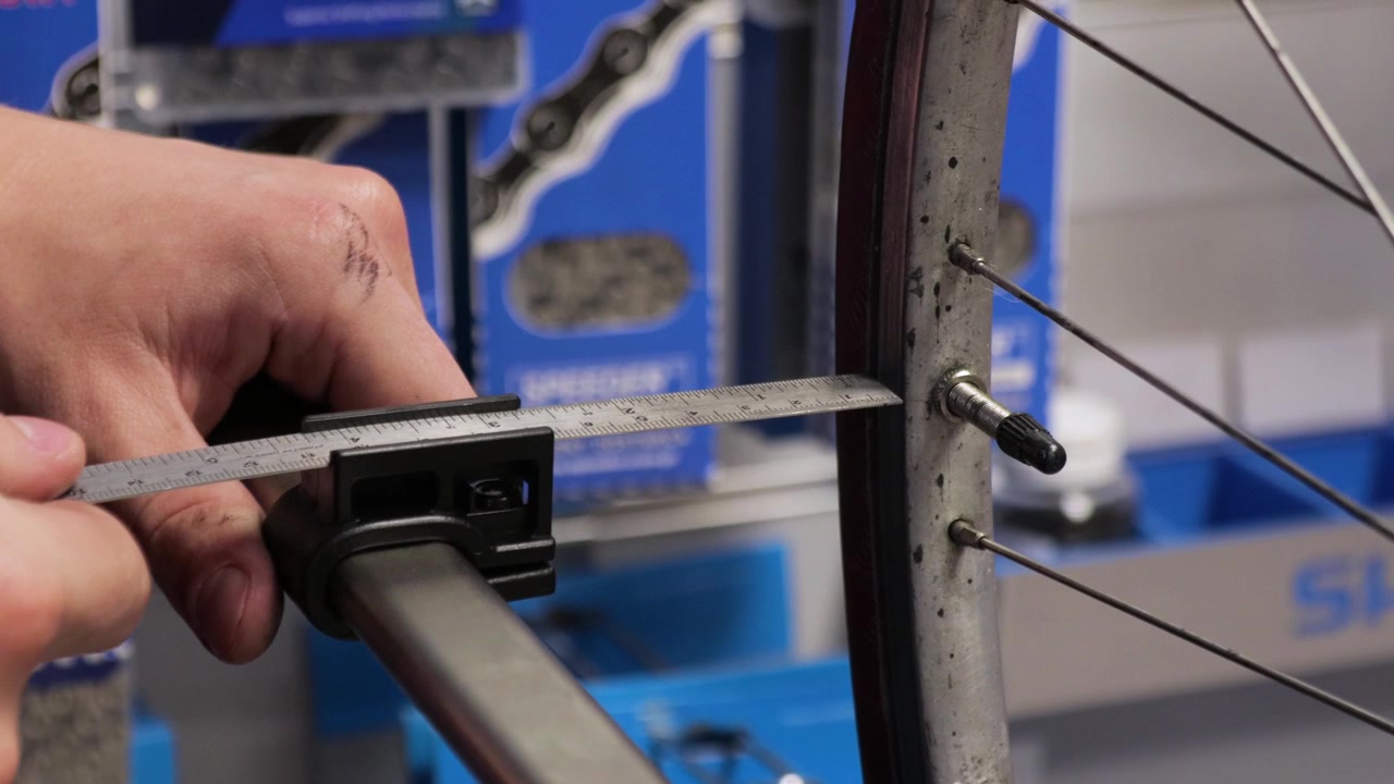 Repairing bicycle at workshop. Straightening derailleur hanger.