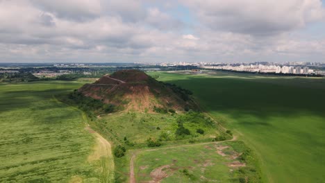 household waste landfill. closed for processing. environment protection. close-up shot. the city is visible on the horizon. aerial photography..