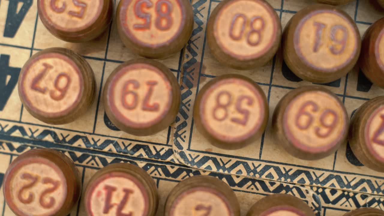 Cinematic close-up smooth shot from above of a pile of Bingo wooden barrels in a row, woody figures, old numbers background, vintage board game, 4K commercial rotating zoom out gimbal video