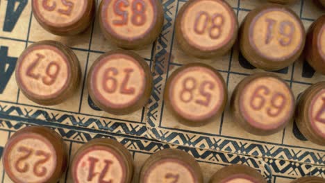 cinematic close-up smooth shot from above of a pile of bingo wooden barrels in a row, woody figures, old numbers background, vintage board game, 4k commercial rotating zoom out gimbal video