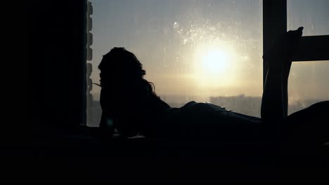 side-view-silhouette-of-graceful-girl-against-bright-sunset