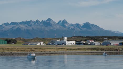 Gesperrte-Aufnahme-Von-Booten,-Die-In-Der-Marina-Von-Ushuaia-Mit-Den-Patagonischen-Bergen-Im-Hintergrund-Schwimmen