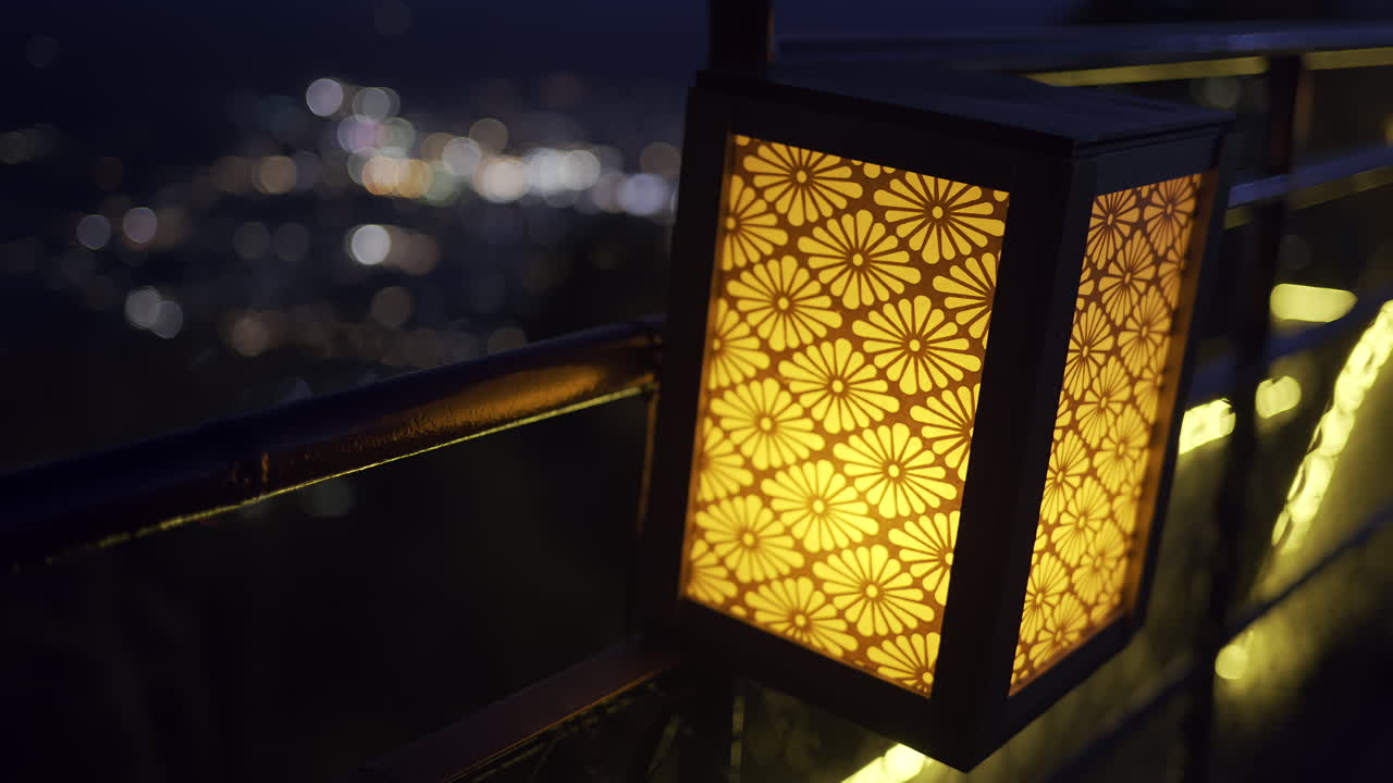 A peaceful evening walk along Fujikawaguchiko viewpoint mountain path reveals a stunning city view. Lanterns glow softly, adding warmth to the nighttime atmosphere as the city lights twinkle below