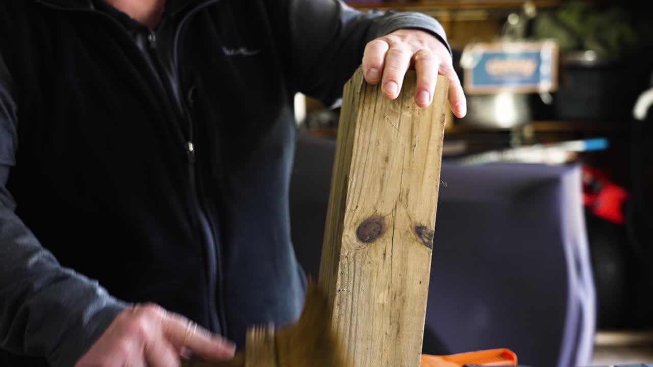 examinando y limpiando un poste de madera