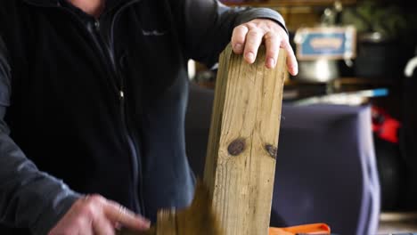 examinando y limpiando un poste de madera