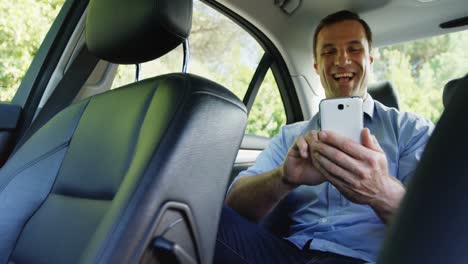 Hombre-Usando-Un-Teléfono-Móvil-En-El-Asiento-Delantero-Del-Auto