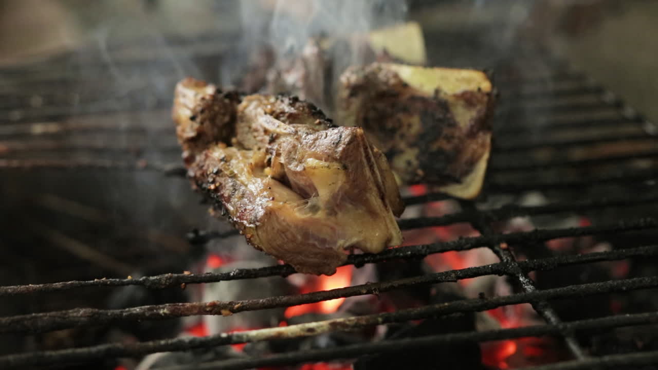 carne a la parrilla sobre parrilla de carbón con humo