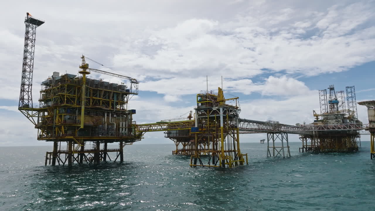 Low-angle dolly shot of big offshore petrochemical processing platform, oil and gas industry