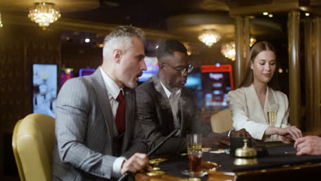jugadores de póquer fumando y bebiendo en el casino.