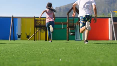 Rear-view-of-mixed-race-schoolkids-playing-in-the-school-playground-4k