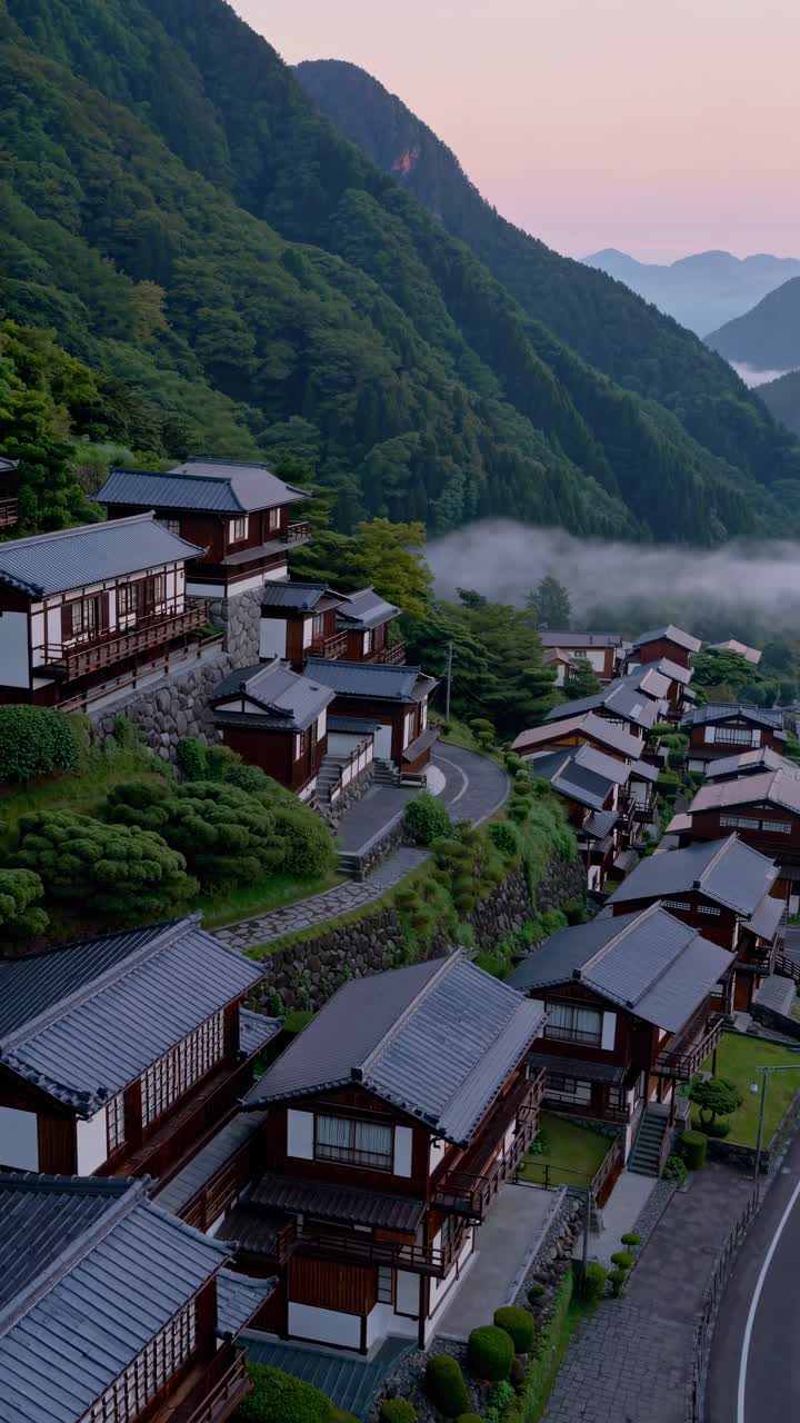 Aerial video captures serene mountain village at sunrise, showcasing traditional wooden houses