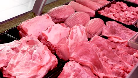 in a lively market, various cuts of fresh meats are displayed, showcasing vibrant pink hues