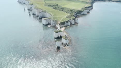 slow descending reveal drone shot of old harry rocks chalk cliffs dorset uk