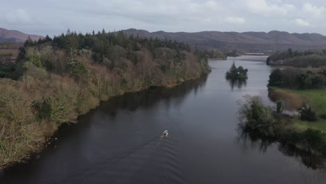 seguimiento aéreo ascendente de un pequeño barco pesquero en un río pintoresco 4k