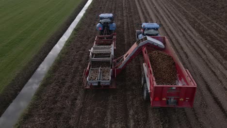 Following-farmers-in-tractors-harvesting-potato-produce-driving-side-by-side