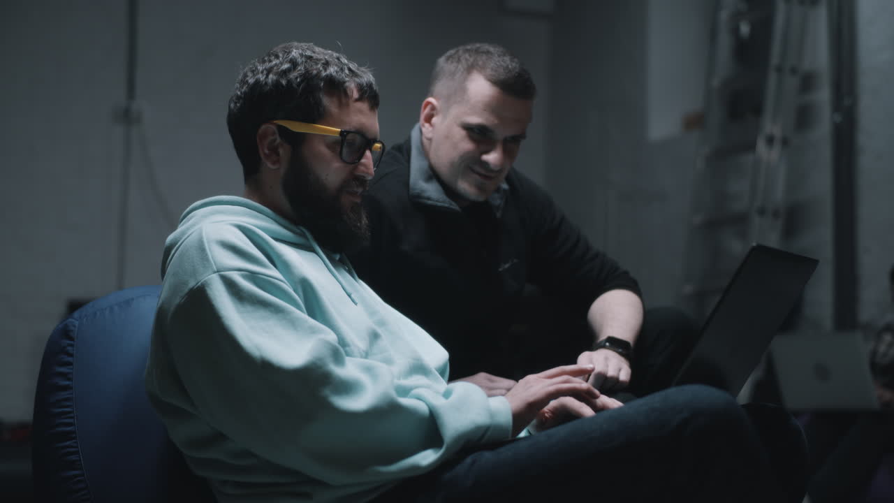 Two men working together on a laptop