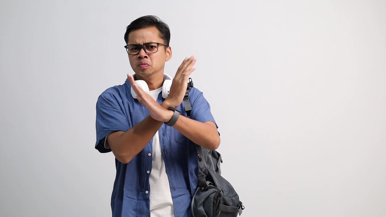 Displeased young asian college student man pointing fingers on himself ask say who me no thanks i do not need it