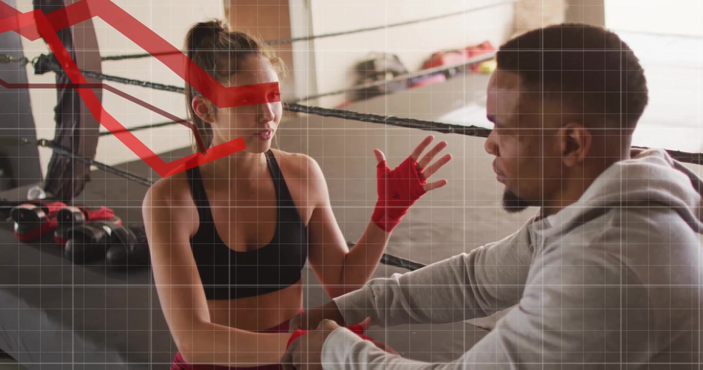 Athlet hebt die rechte Hand, um die Fausttechnik zu erklären, während der Trainer die linke Bandage für das Boxen befestigt.
