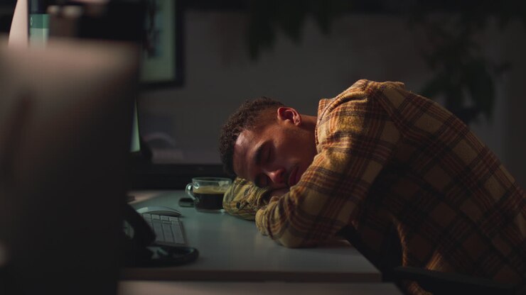 Businessman Working Late In Office Sleeping At Desk