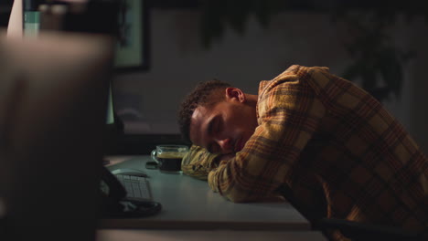 hombre de negocios trabajando hasta tarde en la oficina durmiendo en el escritorio